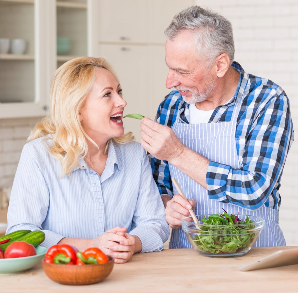 Pareja mayor comiendo vegetales