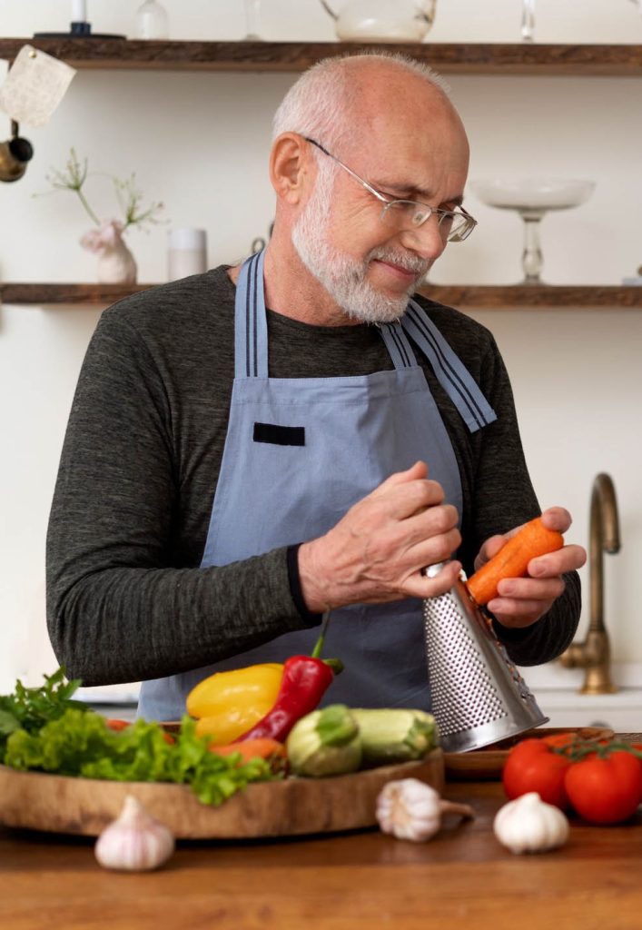 Adulto mayor rayando zanahorias